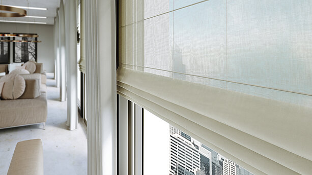 Elegante, halbtransparente Raffrollos und fließende Vorhänge in einem modernen Wohnraum mit bodentiefen Fenstern und Stadtblick.