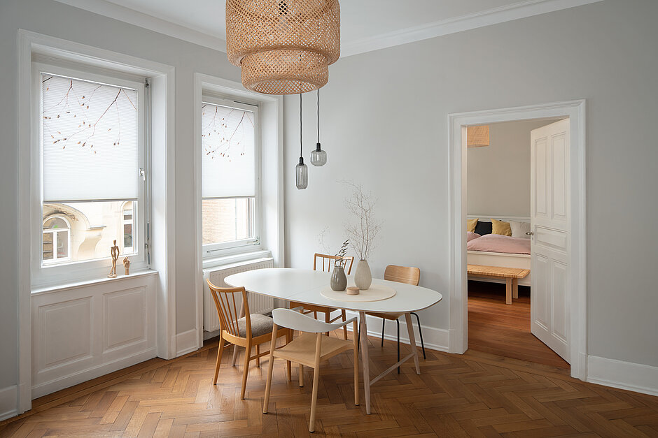 Esszimmer mit zwei Fenstern und weißen Wabenplissees mit zartem Naturmotiv, modern und hell eingerichtet