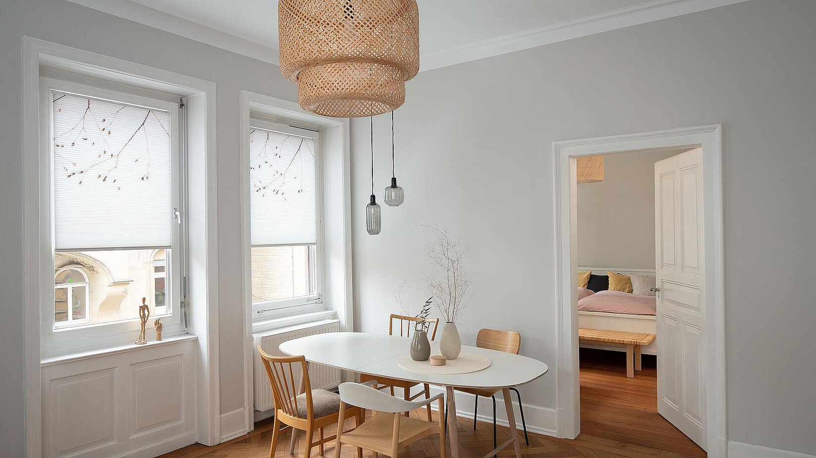 Esszimmer im Altbau mit weißen Holzfenstern und halbtransparenten Wabenplissees mit dezentem Muster für Sicht- und Lichtschutz