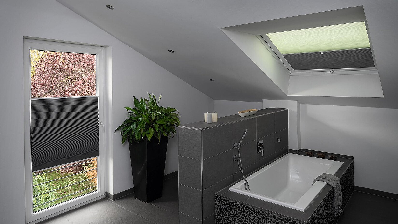 Badezimmer mit grauer Fliesengestaltung, ausgestattet mit Wabenplissees an Dach- und senkrechtem Fenster